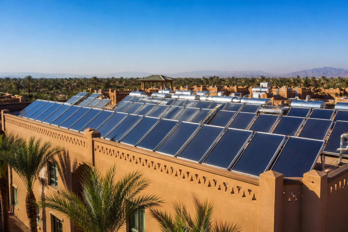 Rangées de capteurs solaires thermiques installées sur le toit-terrasse d'un hôtel au Maroc
